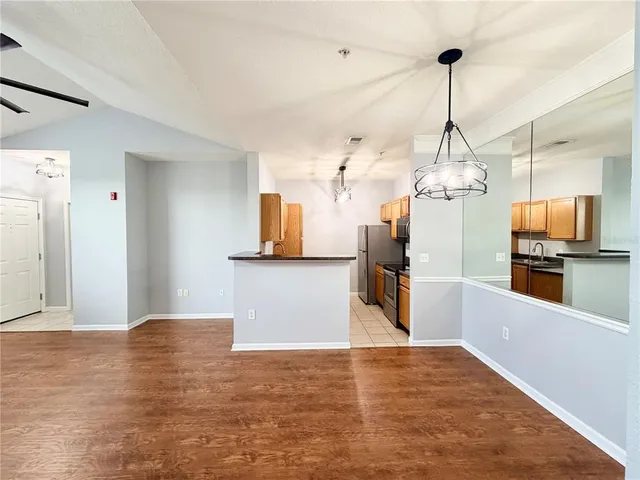 a view of a room with wooden floor and a ceiling fan