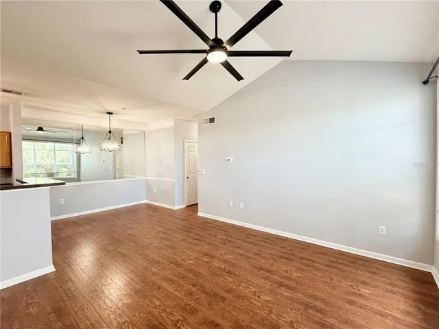 a view of a hallway with wooden floor and chandelier