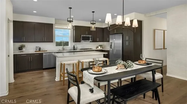 a kitchen with refrigerator and chairs