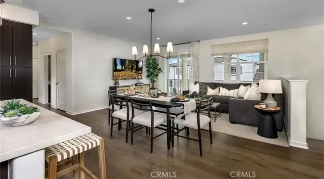 a dining room with furniture a chandelier and wooden floor