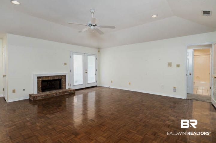 12 Stonebridge Court Mobile, AL 36608 - Photo 7 of 38 Unfurnished living room featuring a ceiling fan, recessed lighting, french doors, a fireplace, and vaulted ceiling