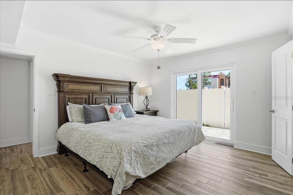 8911 Blind Pass Road, Unit 118 St. Pete Beach, FL 33706 - Photo 25 of 34 a bedroom with a large bed and wooden floor
