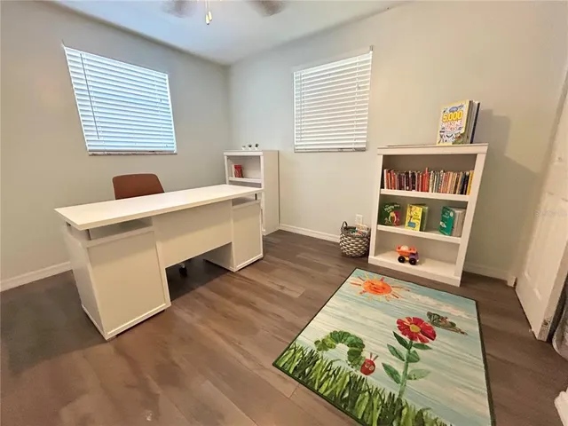 a living room with a baby crib furniture and a wooden floor