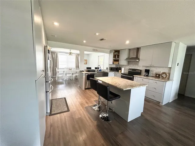 a kitchen with a sink a counter top space a large window and stainless steel appliances