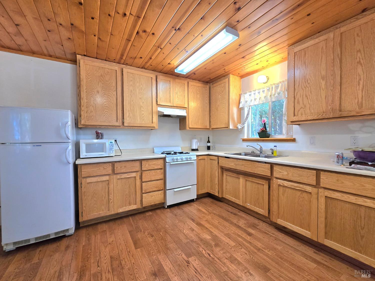 36193 Covelo Road Willits, CA 95490 - Photo 11 of 30 a kitchen with stainless steel appliances granite countertop a sink a stove cabinets counter space and a window