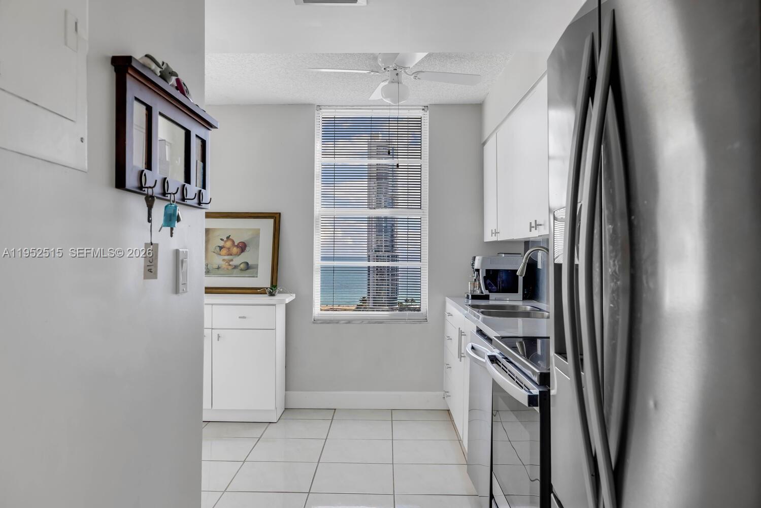 231 174th Street, Unit 2018 Sunny Isles Beach, FL 33160 - Photo 12 of 25 a kitchen with stainless steel appliances a refrigerator and a stove top oven