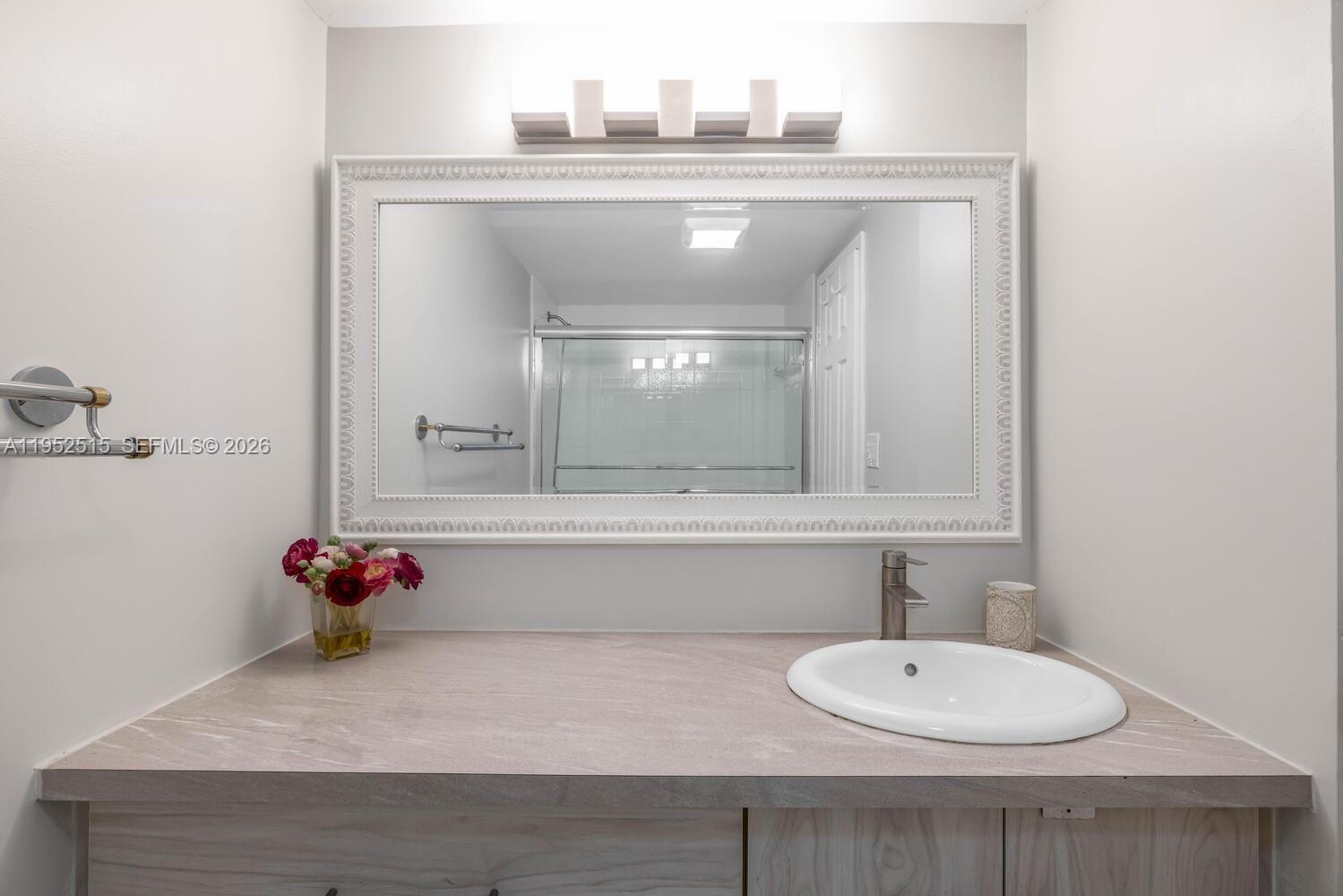 231 174th Street, Unit 2018 Sunny Isles Beach, FL 33160 - Photo 16 of 25 a bathroom with a sink and mirror