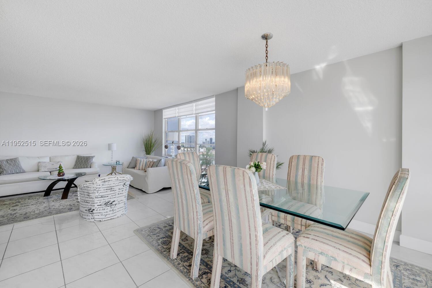 231 174th Street, Unit 2018 Sunny Isles Beach, FL 33160 - Photo 8 of 25 a living room with furniture a chandelier and a wooden floor
