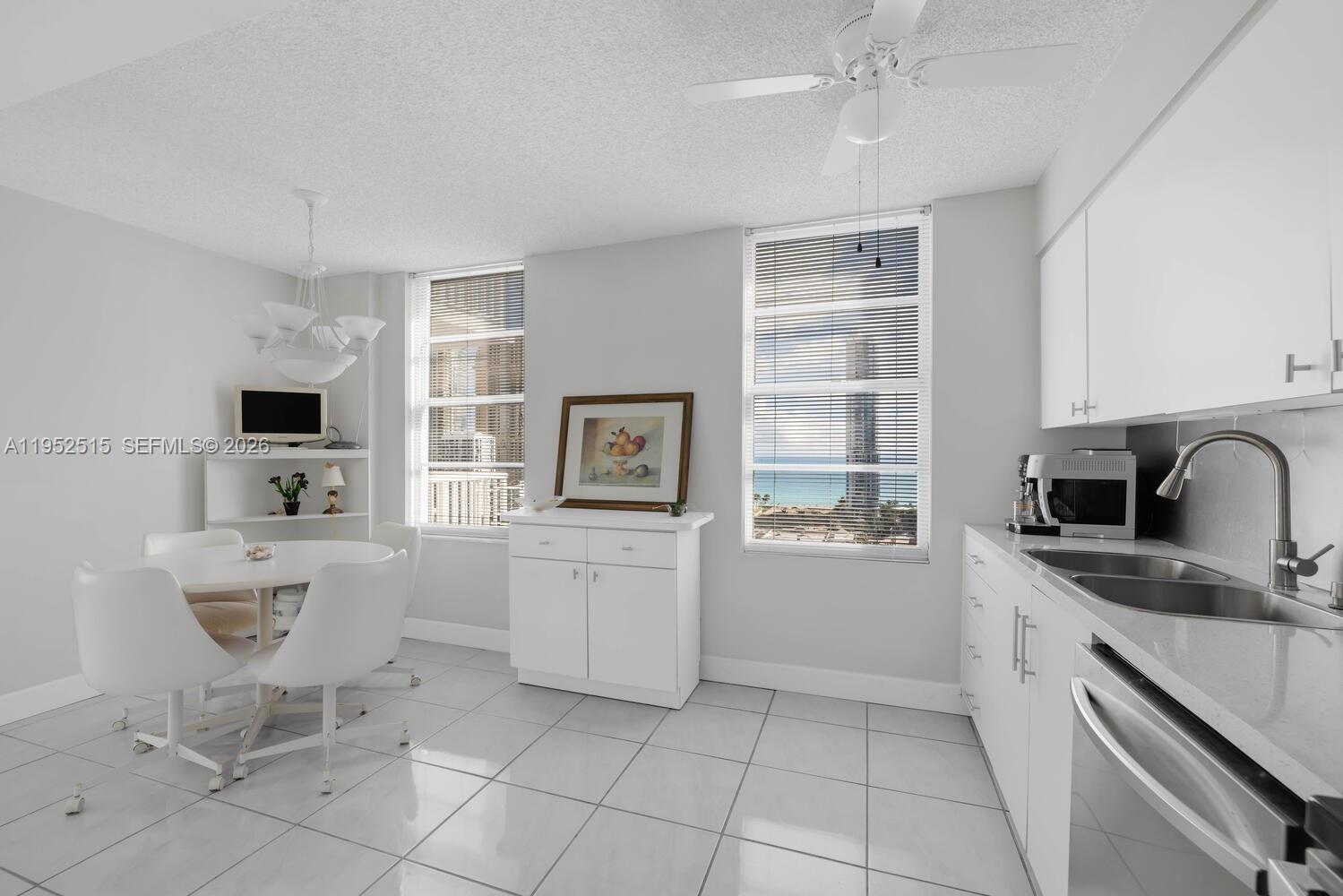 231 174th Street, Unit 2018 Sunny Isles Beach, FL 33160 - Photo 10 of 25 a kitchen with cabinets and chairs