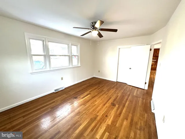 a view of empty room with wooden floor