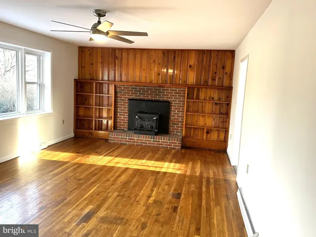 a view of empty room with a fireplace and wooden floor