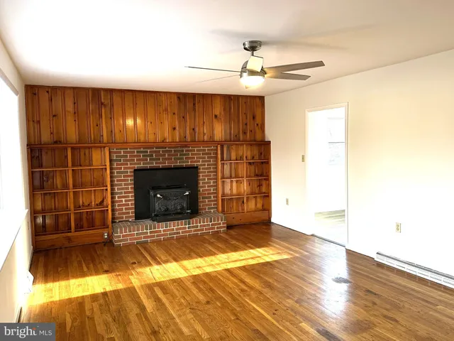 a view of a livingroom with a fireplace and window