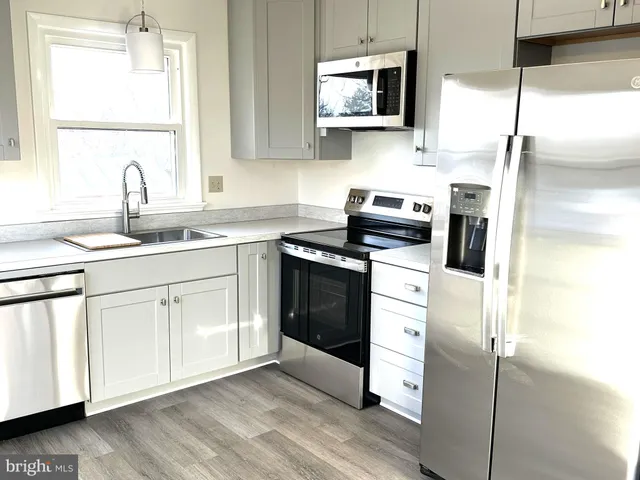 a kitchen with stainless steel appliances granite countertop a sink a stove and a microwave