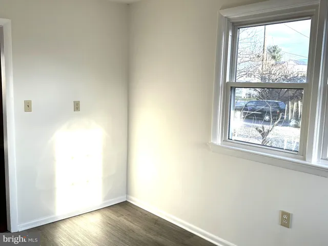 a view of a small space with wooden floor and a window