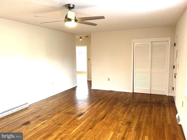 a view of an empty room with wooden floor