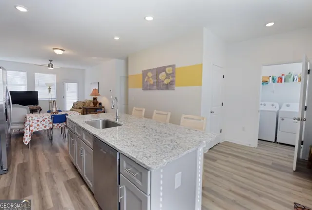 a kitchen with white cabinets sink and stove