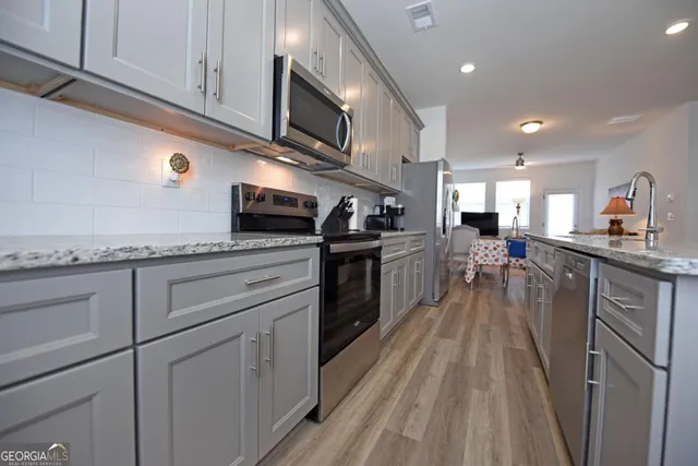 a living room with furniture a flat screen tv and a fireplace