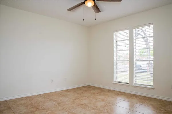 an empty room with fan and windows