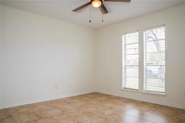an empty room with fan and windows