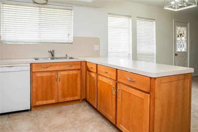 a view of a kitchen with kitchen island a sink wooden floor and a window