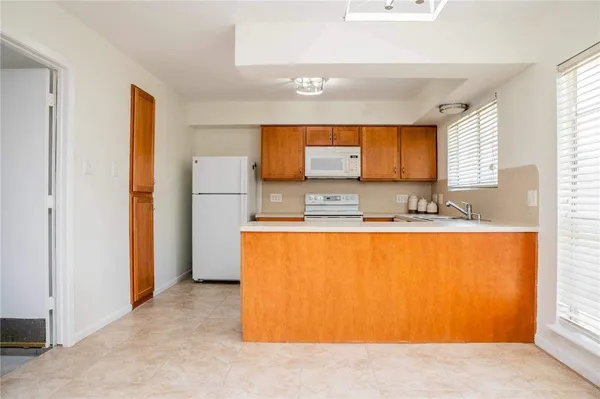a view of a kitchen with stainless steel appliances wooden cabinets and a refrigerator