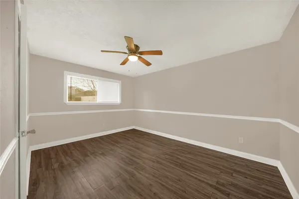 a view of a big room with wooden floor and windows