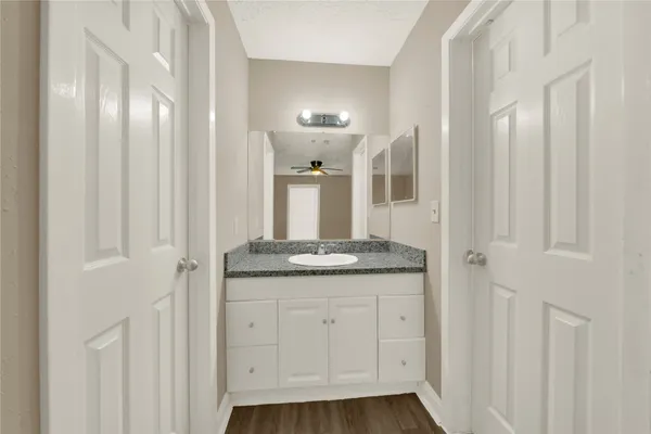 a bathroom with a granite countertop sink and a mirror