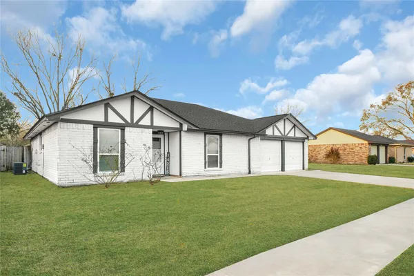 a view of a house with a big yard and large trees