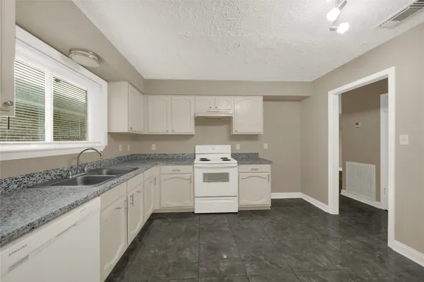 a kitchen with a sink stove and cabinets