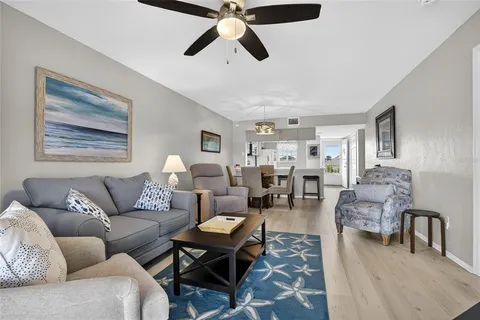 a living room with furniture and a view of kitchen