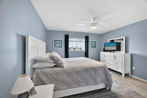 a bedroom with a large bed and flat tv screen on dresser