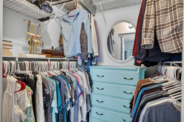 a view of walk in closet with clothes and shoes