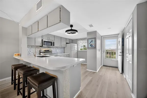a kitchen with stainless steel appliances a stove a refrigerator and a fireplace