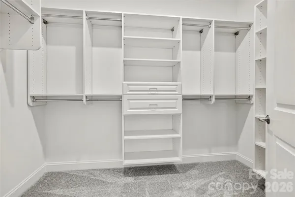 a view of walk in closet with empty racks