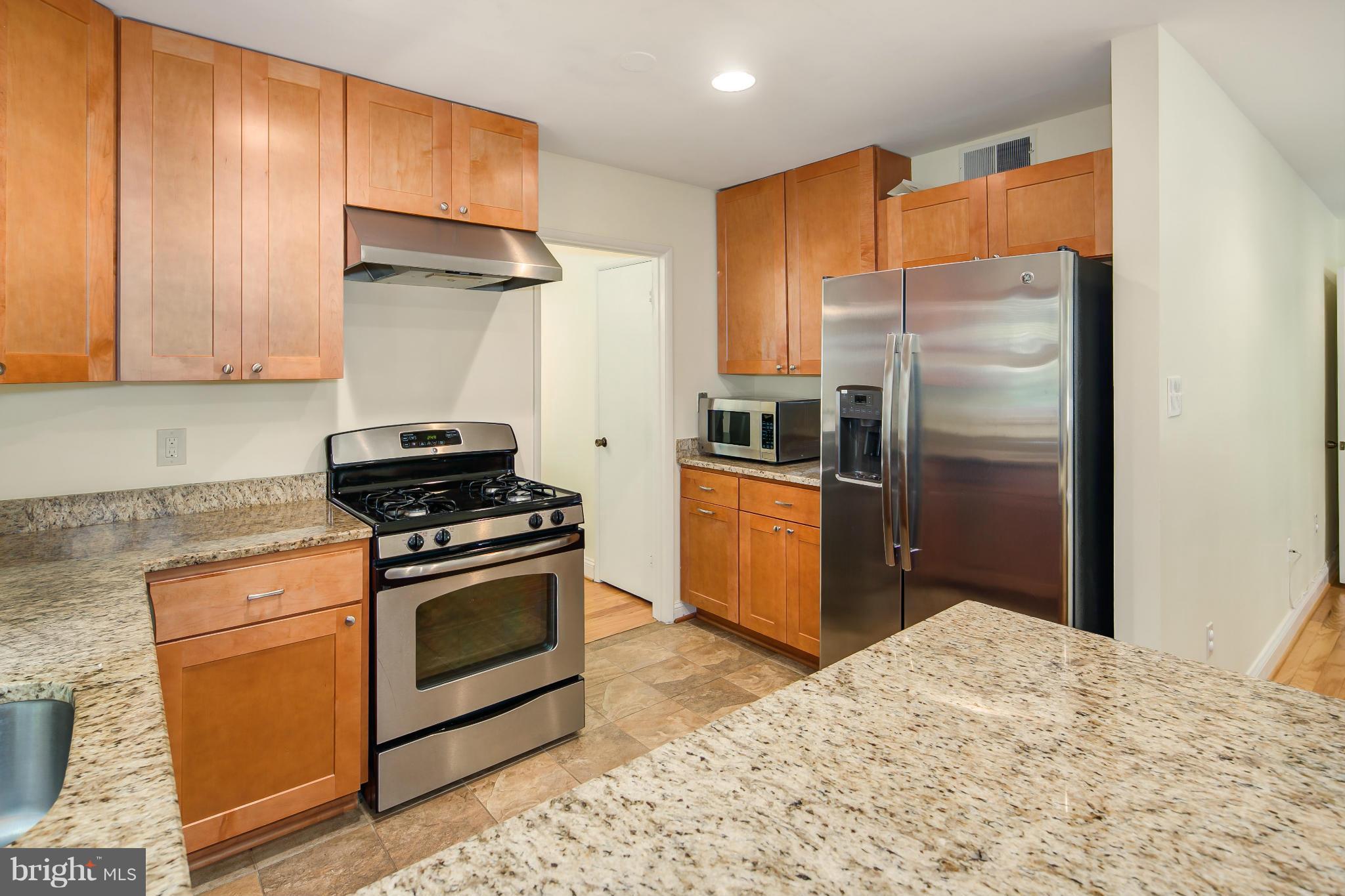 2309 November Lane Reston, VA 20191 - Photo 9 of 29 a kitchen with stainless steel appliances granite countertop a refrigerator a stove and a sink