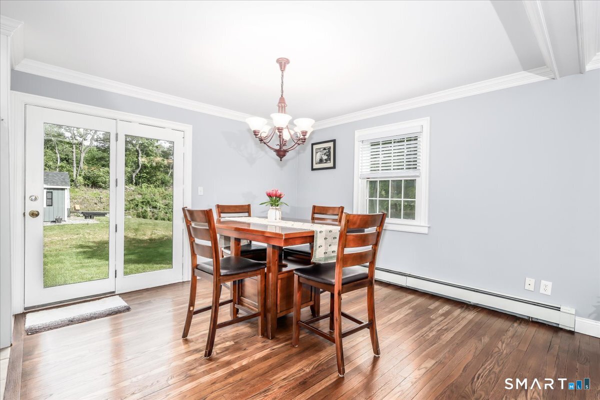 19 Botsford Hill Road Newtown, CT 06470 - Photo 12 of 40 a dining room with wooden floor a chandelier a wooden table and chairs