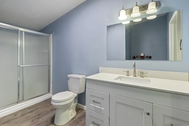 a bathroom with a granite countertop sink a toilet and a mirror