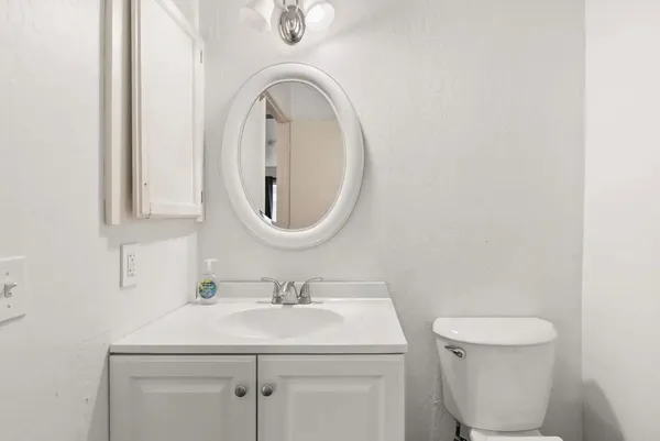 a bathroom with a sink mirror and toilet