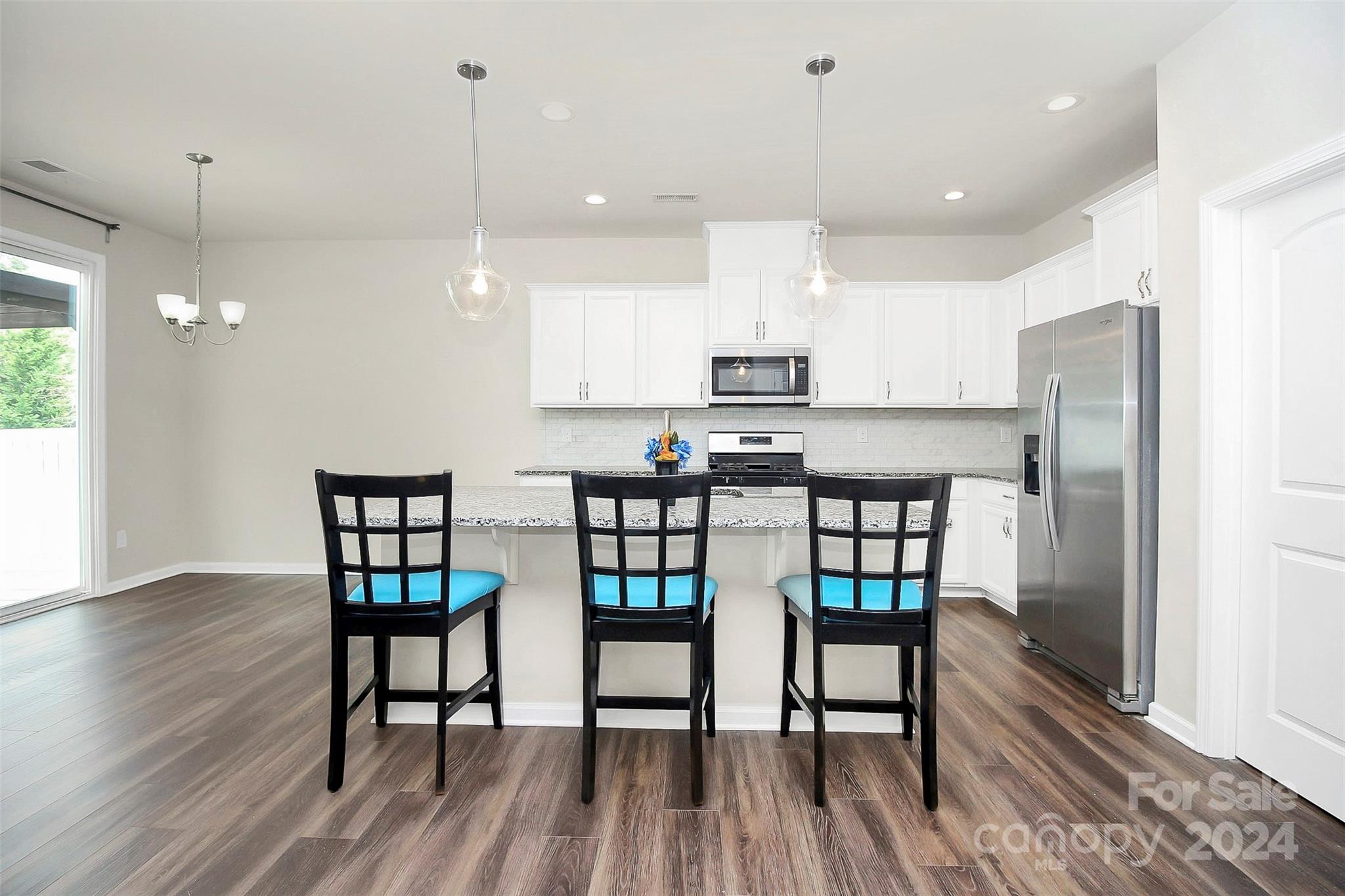 1769 Bailey Ridge Drive York, SC 29745 - Photo 16 of 47 a kitchen with kitchen island a wooden floor and white appliances