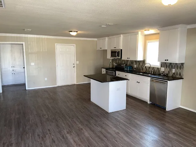 a kitchen with granite countertop a sink and cabinets