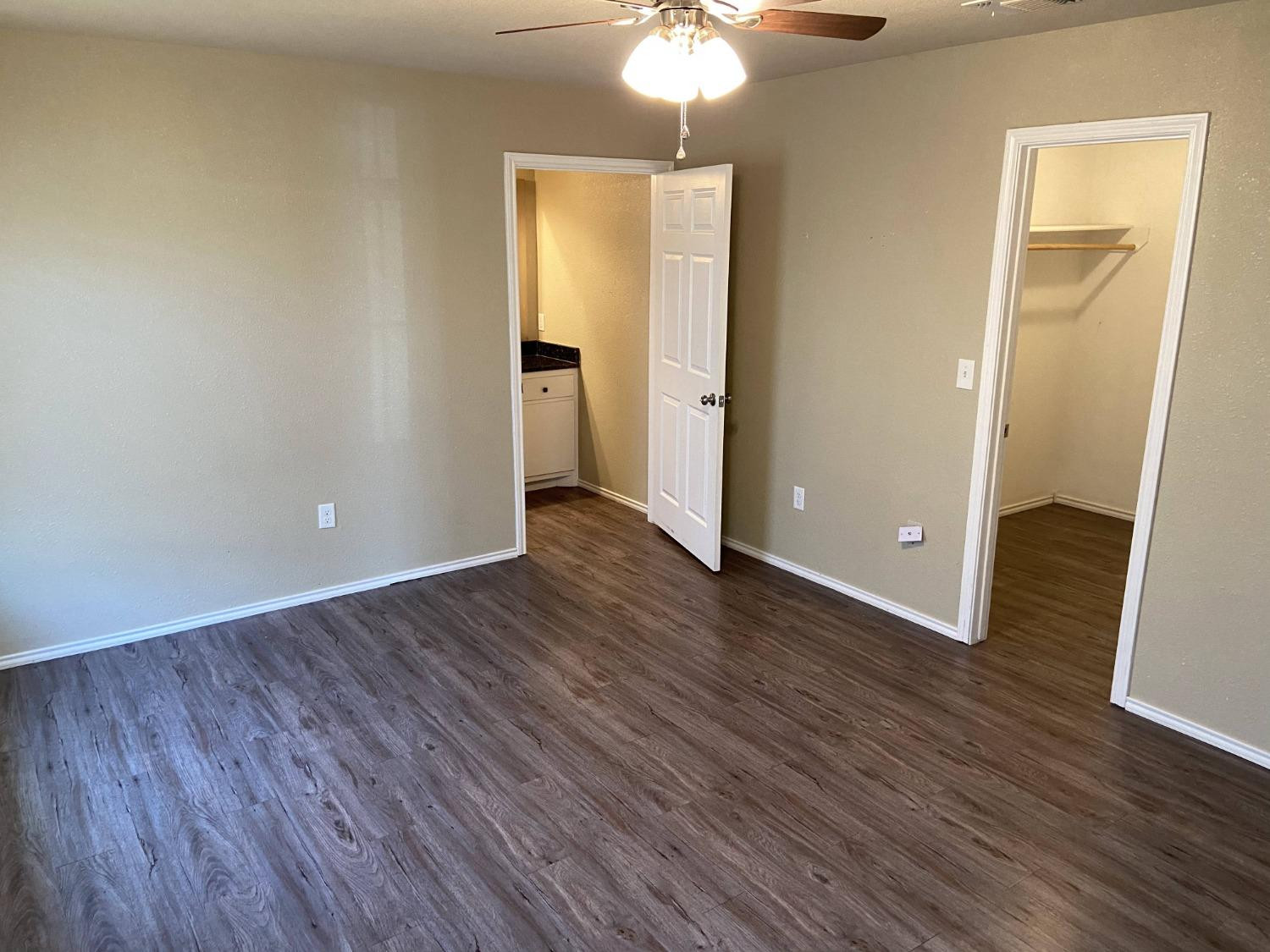 2709 Cornell Street Lubbock, TX 79415 - Photo 10 of 28 an empty room with wooden floor and a ceiling fan