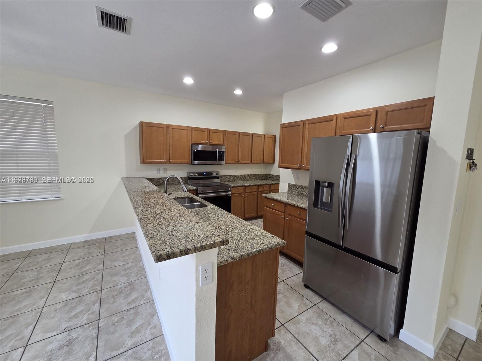 8841 West 34th Court Hialeah, FL 33018 - Photo 21 of 48 a kitchen with stainless steel appliances granite countertop a refrigerator and a stove