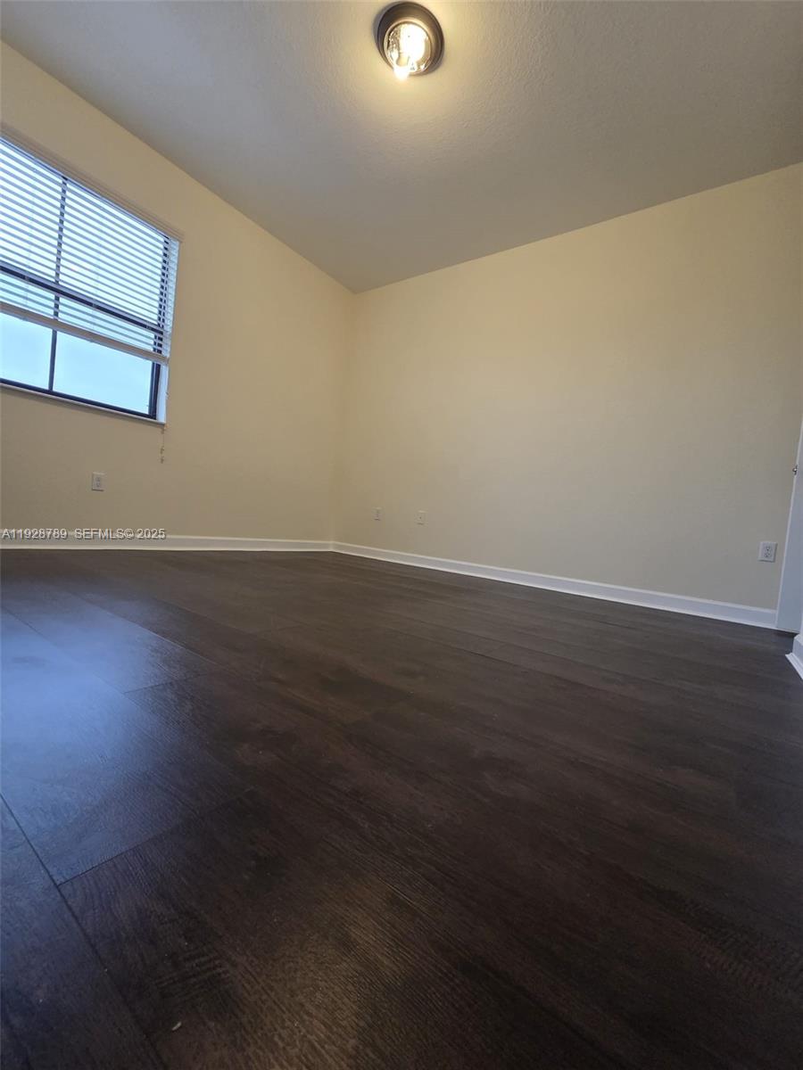 8841 West 34th Court Hialeah, FL 33018 - Photo 22 of 48 an empty room with wooden floor and windows
