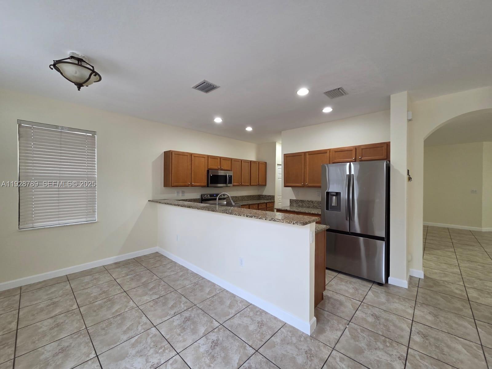 8841 West 34th Court Hialeah, FL 33018 - Photo 29 of 48 a kitchen with a refrigerator and a stove top oven