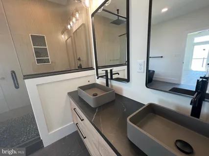 a bathroom with double vanity sinks and a mirror