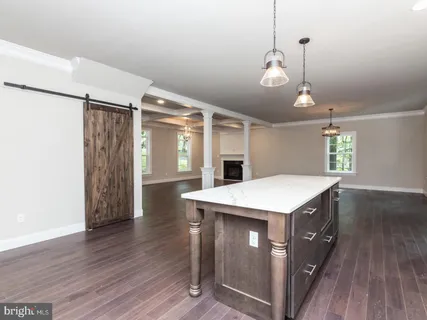 a view of a room with wooden floor staircase and a kitchen view