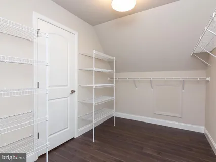 a view of a room with wooden floor chandelier and windows