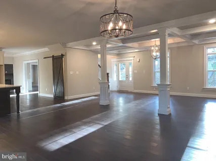 a kitchen with stainless steel appliances a stove a sink a refrigerator white cabinets and wooden floor