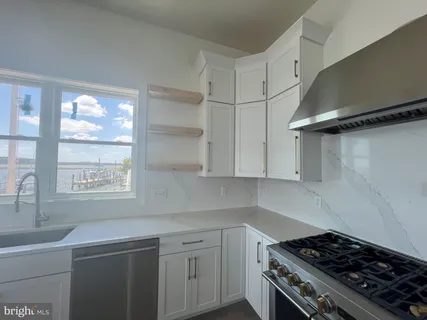 an empty room with wooden floor fireplace and windows