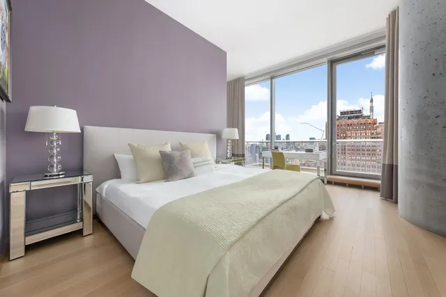 a spacious bedroom with a bed and a lamp